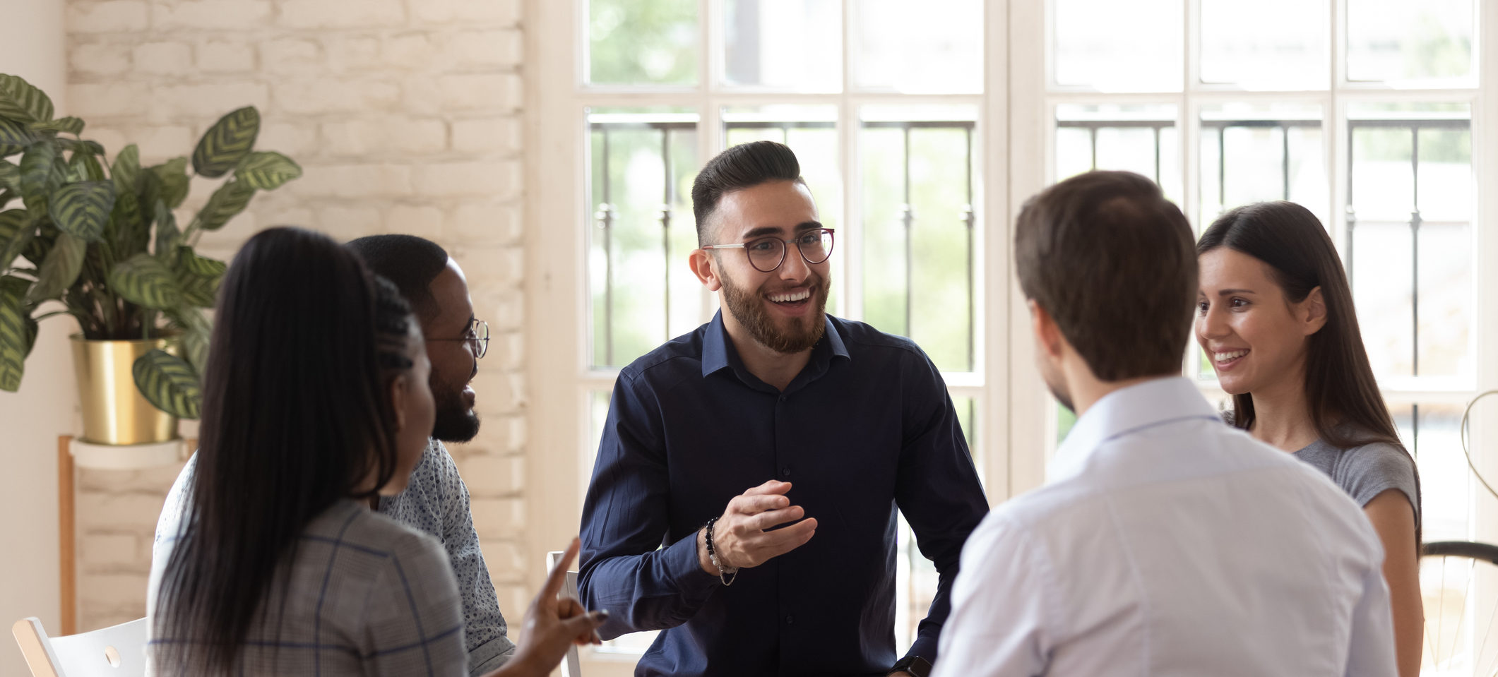 Positive people sit in circle take part in team building or therapy session, try to solve problems or do training exercise, focus on arabian man telling story share experience at group meeting concept